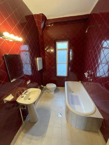 baño de azulejos rojos con lavabo y aseo en Estudio Live en Buenos Aires