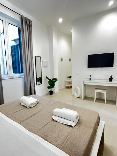 a white room with two pillows on a bed at Valguarnera Studio Apartments in Palermo