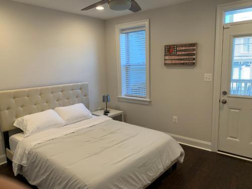 a bedroom with a large bed and two windows at Beautiful Canton Home w/rooftop deck +Private parking in Baltimore