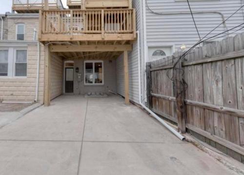 a house with a porch with a deck on top of it at Beautiful Canton Home w/rooftop deck +Private parking in Baltimore