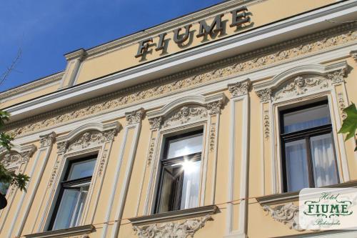 a building with a sign on the side of it at Fiume Hotel in Békéscsaba