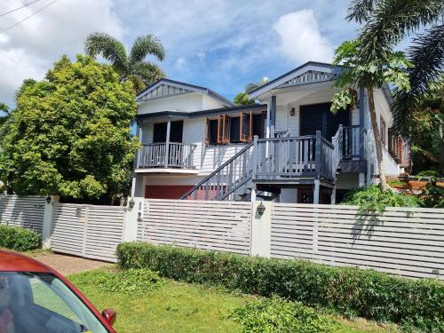 una casa con una recinzione bianca davanti di Homestay at Julie's a Cairns