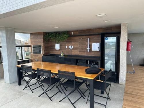 uma cozinha com uma mesa de madeira e cadeiras pretas em Salvador barra em Salvador