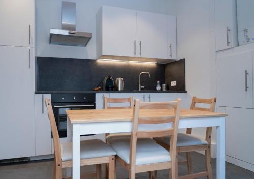 Beau T2 quartier Contades في ستراسبورغ: مطبخ مع طاولة وكراسي خشبية في مطبخ
