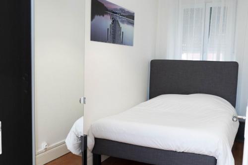 - une chambre dotée d'un lit avec des draps blancs dans l'établissement Beau T2 quartier Contades, à Strasbourg