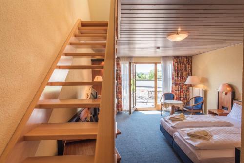 a hotel room with a bunk bed and a staircase at Landhotel und Gasthof Hirsch Hüttenreute in Hoßkirch