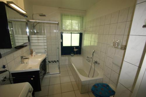 La salle de bains est pourvue d'une baignoire, d'un lavabo et d'une baignoire. dans l'établissement Ostseewelle, à Schönberger Strand