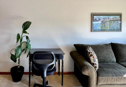 a living room with a couch and a table and a plant at The Peregrine Suite - Comfort and Luxury in the Heart of Kodiak in Kodiak