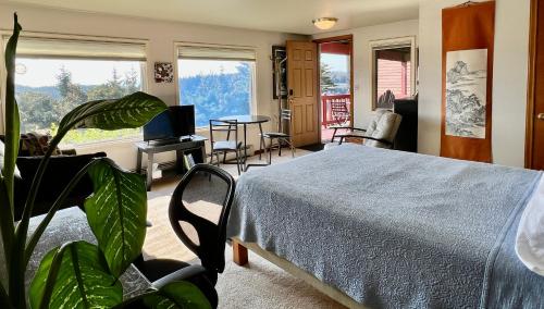 1 dormitorio con 1 cama, mesa y sillas en The Peregrine Suite - Comfort and Luxury in the Heart of Kodiak, en Kodiak