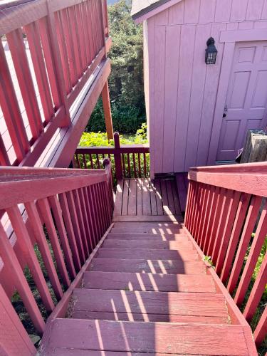 a wooden staircase leading to a house with a purple door at The Peregrine Suite - Comfort and Luxury in the Heart of Kodiak in Kodiak