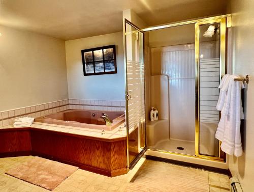 een badkamer met een bad en een douche bij The Peregrine Suite - Comfort and Luxury in the Heart of Kodiak in Kodiak