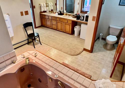 a bathroom with a tub and a sink and a toilet at The Peregrine Suite - Comfort and Luxury in the Heart of Kodiak in Kodiak