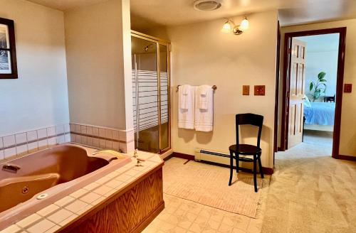 a large bathroom with a large tub and a chair at The Peregrine Suite - Comfort and Luxury in the Heart of Kodiak in Kodiak