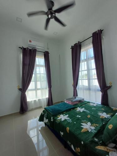 Kampung RajaにあるHomestay Besutのベッドルーム1室(ベッド1台、シーリングファン付)