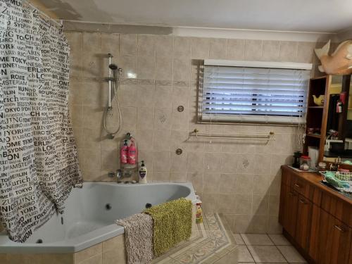 a bathroom with a bath tub and a window at Homestay at Julie's in Cairns