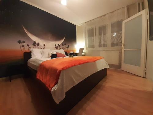 una camera da letto con un grande letto con una coperta arancione di Parkside double room 2 a Budapest