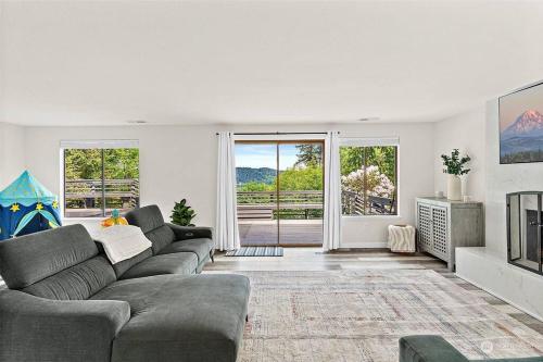 ein Wohnzimmer mit einem Sofa und einem TV in der Unterkunft Secluded Sanctuary With a View of The Puget Sound in Gig Harbor