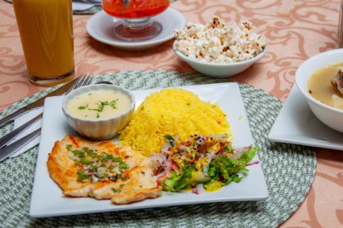 a plate of food on a table with rice and food at Hotel Campanario in Cuenca