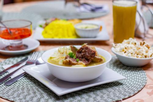 a bowl of food on a plate on a table at Hotel Campanario in Cuenca