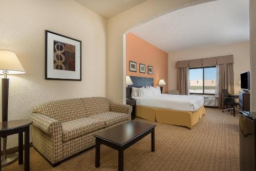 a hotel room with a bed and a couch at Holiday Inn Express and Suites Lafayette East, an IHG Hotel in Lafayette