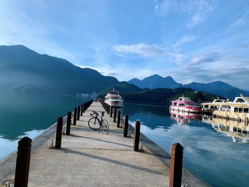 a bike parked on a dock with boats in the water at 日月對白 日月潭 2024全新開幕 in Yuchi