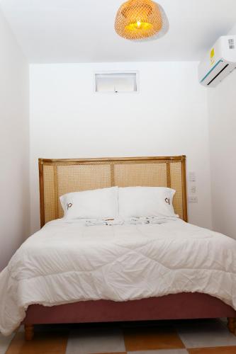 a bedroom with a large white bed with a chandelier at Hostal Casa Torres Centro Historico - Adults Only in Cartagena de Indias