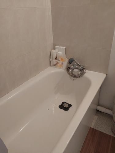 eine weiße Badewanne mit Dusche im Bad in der Unterkunft DANA S HOME in La Courneuve