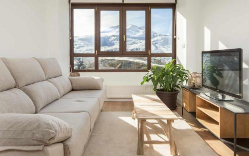 a living room with a couch and a tv at Elurra II Confort in Formigal