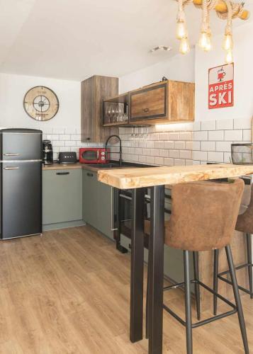 a kitchen with a wooden table and a refrigerator at Elurra II Confort in Formigal