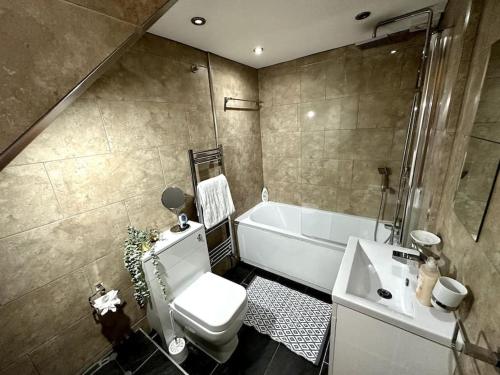 ein Badezimmer mit einer Badewanne, einem WC und einem Waschbecken in der Unterkunft 2 Bed Sleeps 6 - Walking distance to Leeds City Centre!! in Leeds