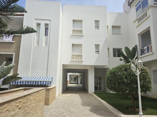un edificio blanco con un pasillo que conduce a él en appartement in al hoceima, en Alhucemas