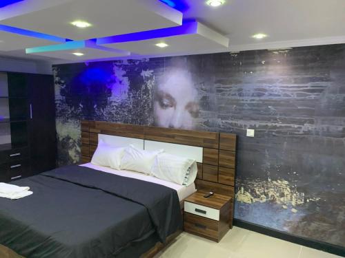 a bedroom with a bed with a large painting on the wall at Luxurious B in Lagos