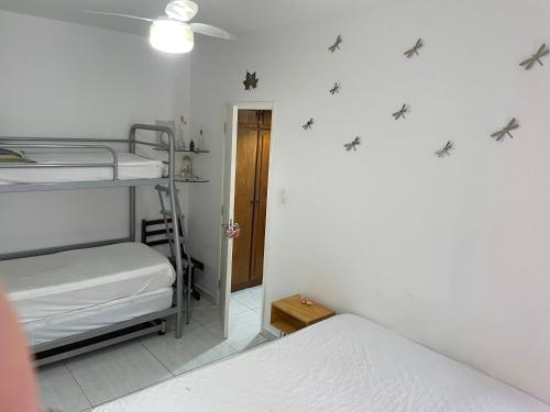 1 dormitorio con 2 literas y ventilador de techo en Charmoso apartamento 01 Quarto Enseada en Guarujá