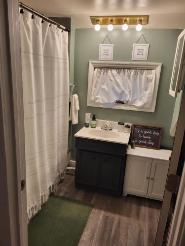 a bathroom with a sink and a mirror at Cozy Little Getaway in Winner