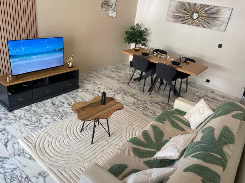ein Wohnzimmer mit einem Sofa und einem TV in der Unterkunft New apartment at 150m from the beaches Easy check in in Juan-les-Pins