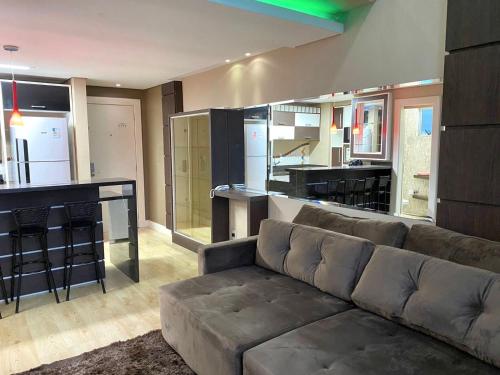 a living room with a couch and a kitchen at Saint Sebastian Flat 612 - Com Hidro! até 4 pessoas, Duplex, no centro in Jaraguá do Sul
