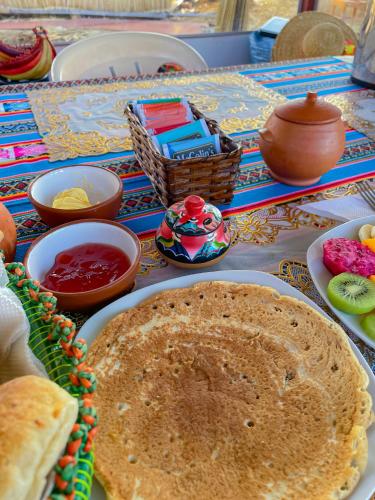 a table with a plate of pancakes and other foods at Lake View Lodge in Puno