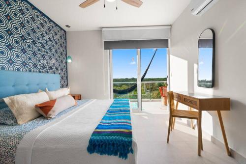 1 dormitorio con cama, escritorio y ventana en 3 bedroom luxury condo next to beach & pools, ac and internet, en Akumal