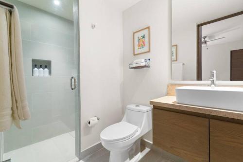 3 bedroom luxury condo next to beach & pools, ac and internet في أكومال: حمام مع مرحاض ومغسلة ودش