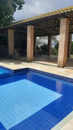 uma grande piscina azul com um pavilhão em Casa Viçosa 5km centro em Viçosa do Ceará