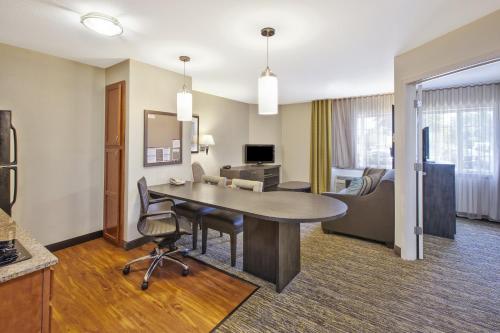 a hotel room with a table and a couch at Candlewood Suites Indianapolis Airport by IHG in Indianapolis