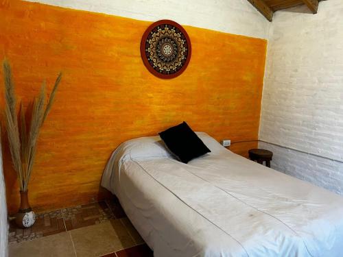 a bedroom with a bed with a black pillow on it at RAMA GUEST HOUSE in Ciudad Lujan de Cuyo