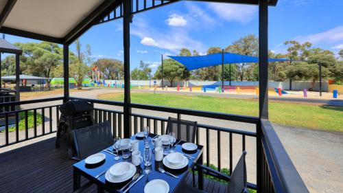 a table on a deck with a view of a park at BIG4 Swan Hill in Swan Hill