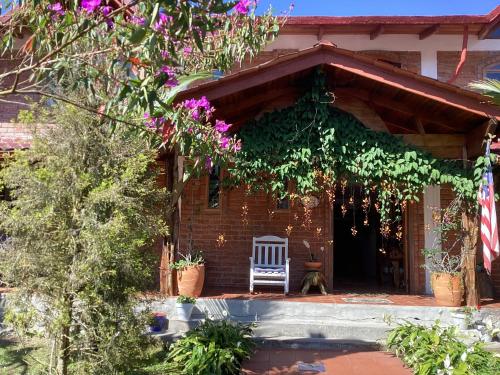 a brick house with a white chair in front of it at La Casa del Rio B&B in Puyo