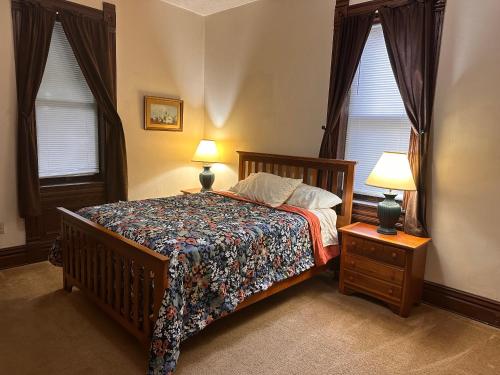 a bedroom with a bed with two lamps and two windows at Dover Historic Building 1Bed w/Hot Tub 1st floor in Dover