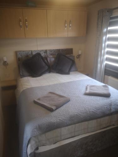 a bedroom with a large bed with two towels on it at The Powers in Rhyl