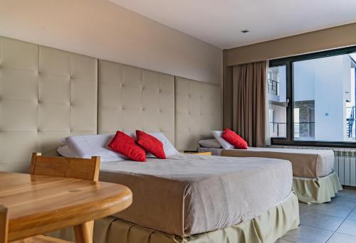a hotel room with two beds with red pillows at Miralejos in Ushuaia