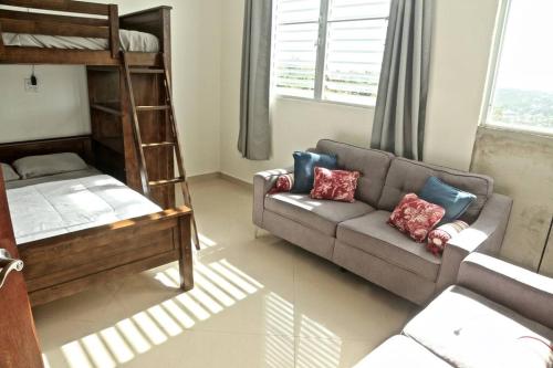 a living room with a couch and a bunk bed at Casa Carmen Culebra- Atenas in Culebra