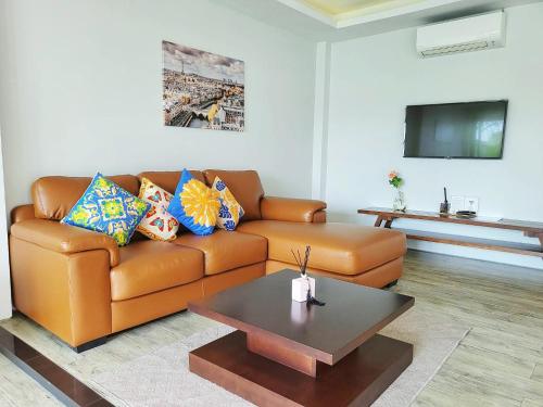 uma sala de estar com um sofá e uma mesa de centro em E villa near bangtao beach ,普吉高端社区邦涛区度假村私人泳池别墅 em Bang Tao Beach