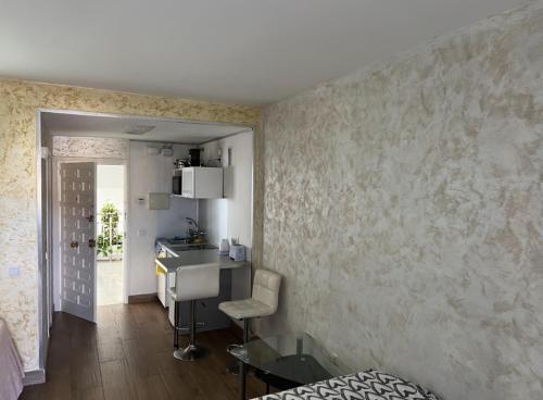 ベナルマデナにあるBenal Beach Apartmentのベッドと椅子が備わる壁のある客室です。